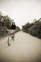 Woman biking on small rural road. Photo. Chris Hackett