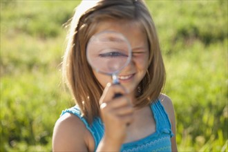 Young girl holding a magnifying glass. Photo. Mike Kemp
