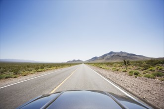 Car driving on highway through the desert. Photo. Chris Hackett
