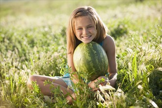 Young girl holding a watermelon. Photo : Mike Kemp