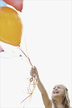Young girl holding balloons. Photo. momentimages