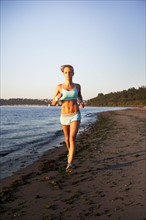Woman running on the beach. Photo. Take A Pix Media