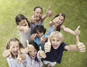 Group of children with their thumbs up. Photo : momentimages