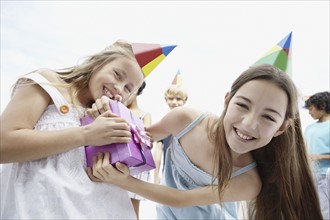 Two girls fighting over birthday present. Photo. momentimages