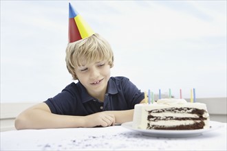 Young boy waiting for a slice of birthday cake. Photo : momentimages