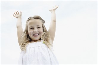 Young girl with her arms raised. Photo. momentimages