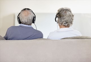 Senior couple wearing headphones. Photo. momentimages