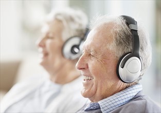 Senior couple wearing headphones. Photo : momentimages