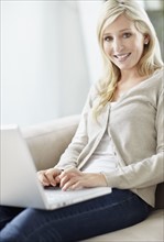 Attractive blond woman browsing the internet. Photo : momentimages