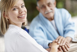 Nurse and senior man holding hands. Photo. momentimages