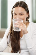 Woman drinking a glass of water. Photo. momentimages