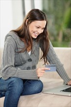 Brunette woman shopping online. Photo : momentimages