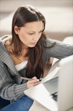 Woman concentrating while doing paperwork. Photo. momentimages