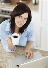 Brunette woman drinking coffee. Photo : momentimages