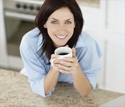 Brunette woman drinking coffee. Photo. momentimages