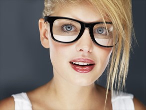 Blond woman wearing glasses and glossy lipstick. Photo. momentimages