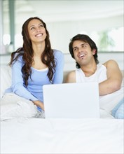 Couple looking at laptop together. Photo : momentimages