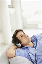 Man listening to music on headphones. Photo : momentimages