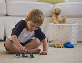 Young boy playing with toy soldiers. Photo. Daniel Grill