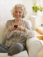 Cheerful woman texting. Photo : Daniel Grill