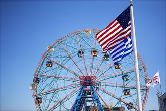 Flags in front of Ferris wheel. Photo : fotog