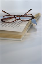Reading glasses on book. Photo. Daniel Grill