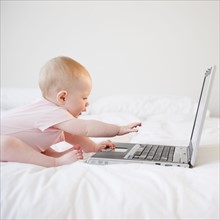 Baby playing with laptop. Photo. Jamie Grill