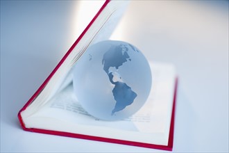 Globe inside a book.