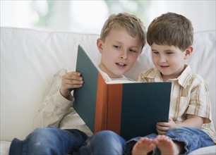 Brothers reading a book together.