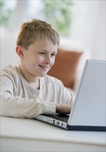 Young boy looking at laptop.