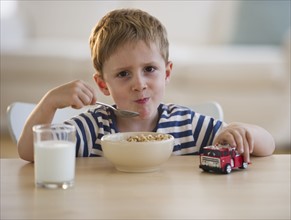 Young boy eating cereal. Photo : Daniel Grill