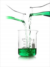 Green liquid being poured into measuring cup. Photo. David Arky