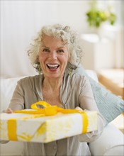 Surprised woman receiving a birthday gift. Photo : Daniel Grill