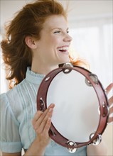 Woman playing tambourine. Photo : Jamie Grill