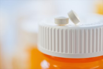 Pills on top of bottle of prescription medication.