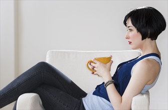 Woman relaxing with cup of coffee. Photo : Daniel Grill