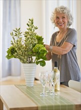 Woman arranging flowers in a vase. Photo : Daniel Grill