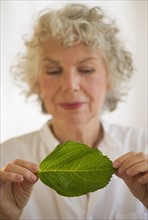 Woman holding a green leaf. Photo : Daniel Grill