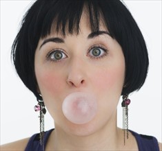 Woman blowing a bubble with bubble gum. Photo. Daniel Grill
