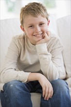 Young boy sitting on couch.
