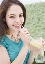 Young woman drinking lemon water. Photo : Jamie Grill
