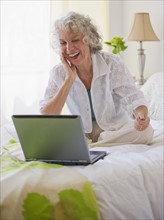 Cheerful woman looking at laptop. Photo : Daniel Grill