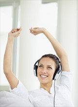 Woman listening to music on headphones. Photo. momentimages