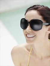 Brunette wearing large sunglasses. Photo. momentimages