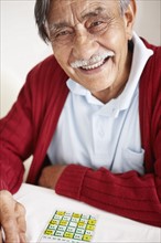 Senior man playing bingo. Photo : momentimages
