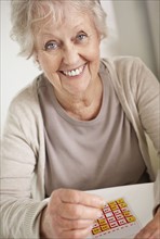 Senior woman playing bingo. Photo. momentimages