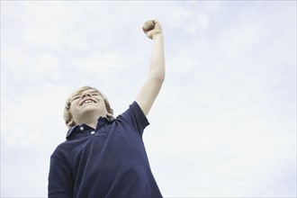 Young boy with his arm raised. Photo. momentimages