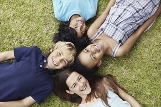 Four friends lying on the grass. Photo. momentimages