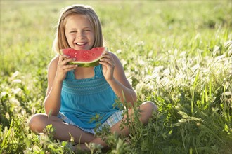 Young girl eating a slice of watermelon. Photo : Mike Kemp