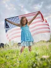 Young girl holding American flag. Photo : Mike Kemp
